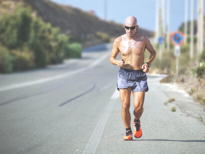 Hombre trota sobre el asfalto de una corretera en Creta, Grecia