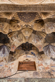 The vaulted ceiling at the entrance of the Ganjali Bathhouse, built in 1631 as part of a larger architectural complex in the old center of Kerman, Iran, features frescoes adorned with Safavid-era ornaments