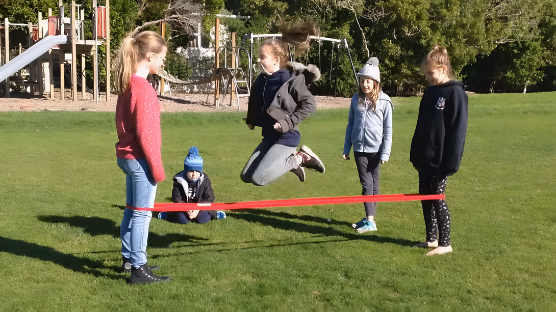 El elástico noble de dos niñas que juegan a saltar sus infancias