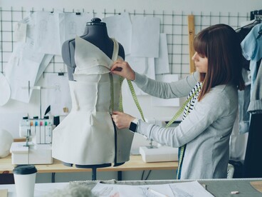 A fashion designer arranging and measuring fabric on a mannequin, symbolizing g how every piece of material can become part of an intentional design