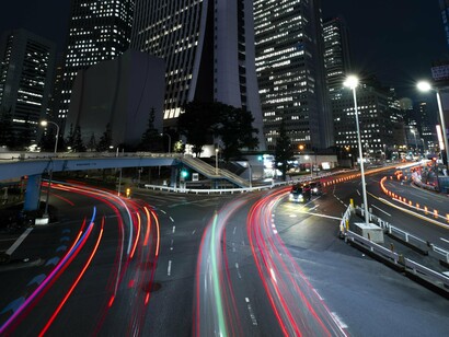 The city at night becomes a monument to humanity’s restless drive for progress