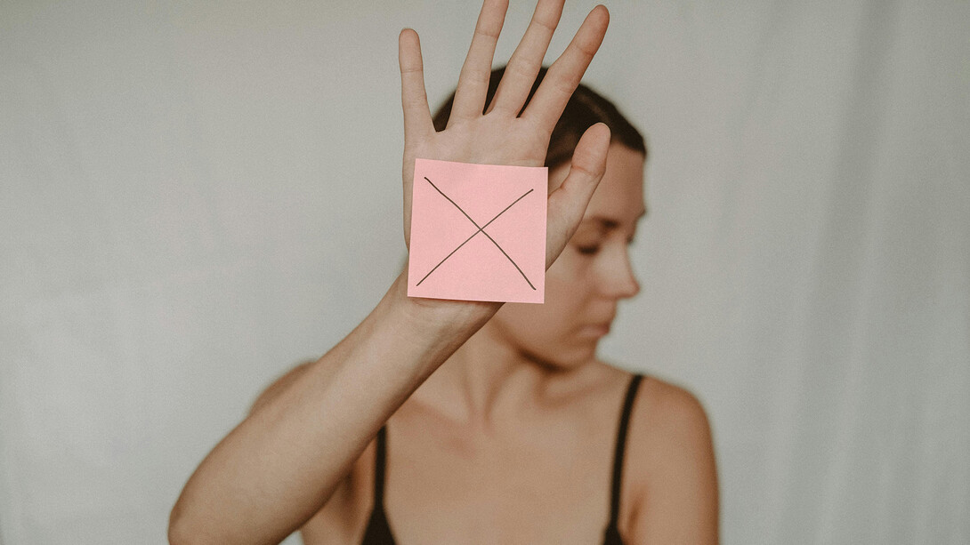 Una giovane donna posa per dire no alla violenza sulle donne