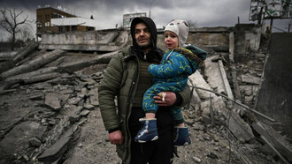 Padre e hijo entre los escombros durante la guerra en Ucrania