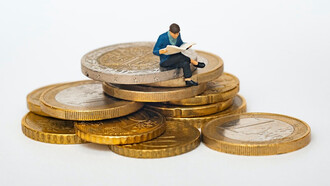 Sculpture of a person sitting on coins and thinking deeply