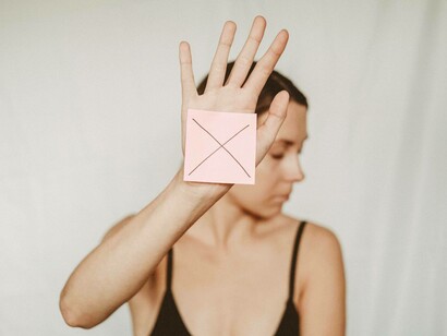 A woman holding an X against control