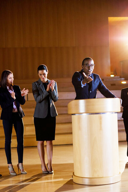 As people applaud a person receiving an award in a high-trust society, it highlights the connection between public trust, effective governance, economic prosperity, and the ongoing efforts to reduce social inequality