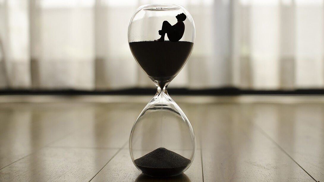 An hourglass resting on the floor, time slipping away, a poignant symbol of life's transience