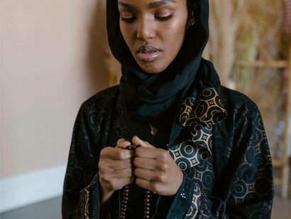 Muslim woman recites prayer with rosary beads