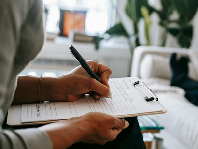 During a therapy session, a psychologist takes notes while discussing mental health concerns with a patient