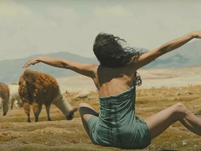 Key-frame di Fatima Lazarte in un campo circondata dagli alpaca, nel docu-film di Fabrizio Catalano, "Irregulàr" 