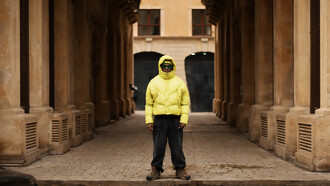 A young man wearing an oversized puffer jacket and wide-leg pants, embracing a trendy look