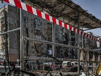 A fotografia de Aleś Uściнаў registra um ponto de ônibus destruído em Kyiv, na Ucrânia, em meio aos vestígios de um ataque. A estrutura danificada evidencia como a guerra ultrapassa as linhas de frente e atinge os espaços comuns da população, comprometendo a mobilidade e a segurança de quem vive nas cidades afetadas pelo conflito