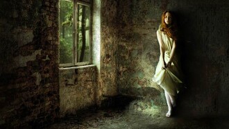 Una mujer sola dentro de una casa en el campo