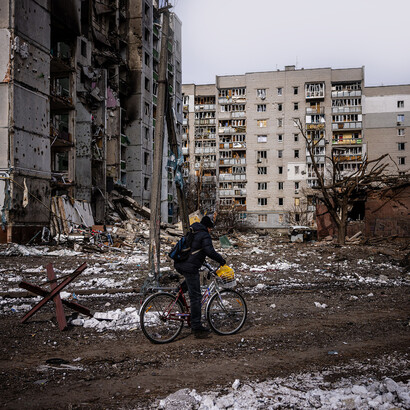 Un hombre monta su bicicleta cerca de edificios residenciales dañados en Chernihiv, Ucrania, el 4 de marzo de 2023