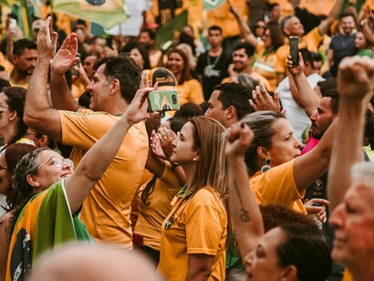 A multidão ocupa uma via pública brasileira durante as manifestações que se seguiram à eleição presidencial de 2022, em meio a bandeiras e símbolos nacionais. Parte dos apoiadores de Jair Bolsonaro passou a contestar o resultado das urnas e a defender a intervenção das Forças Armadas, em um movimento que colocou em evidência a fragilidade da cultura democrática diante de discursos autoritários