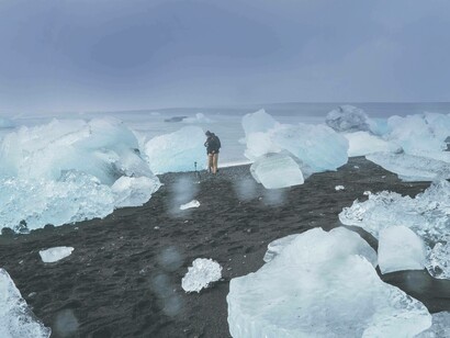 A man standing amongst broken pieces of the ice caps as a result of climate change