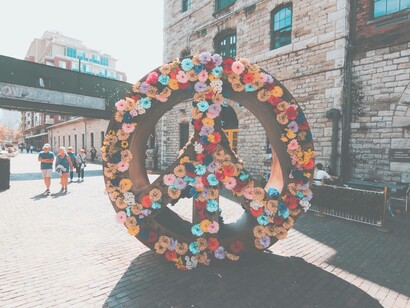 A reef for peace decorated with colorful flowers stands tall in the middle of a pedestrian square