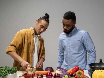 Friends carefully preparing wholesome ingredients, symbolising how healthy habits are strengthened through collaboration