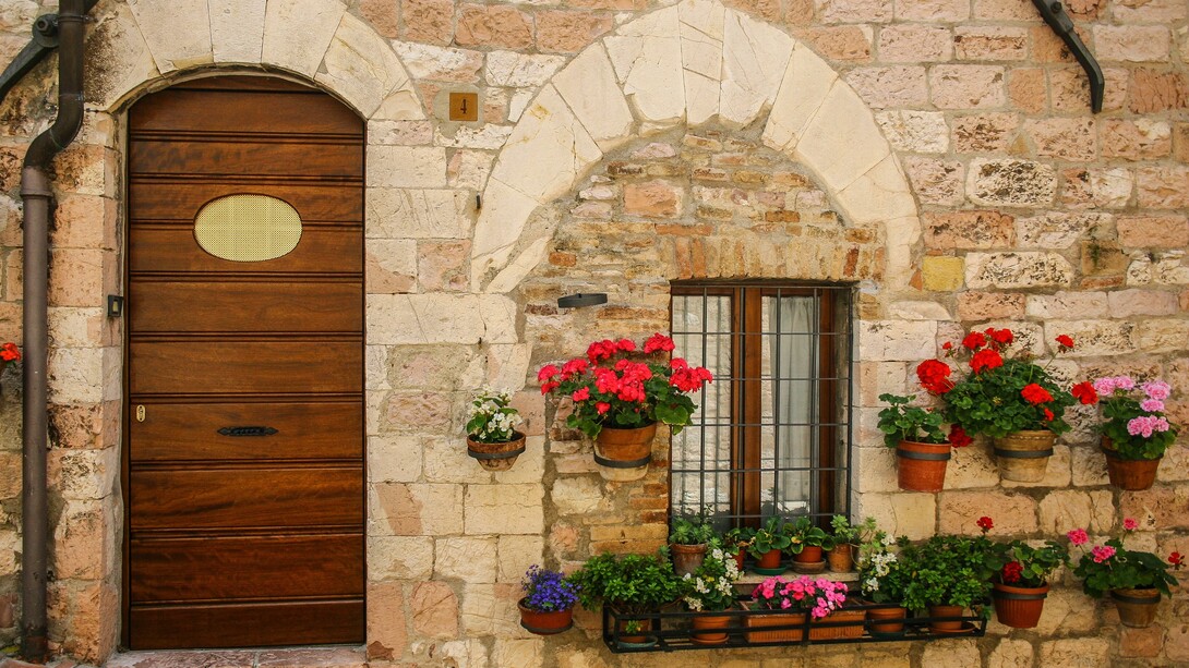 A charming Italian house adorned with flowers on the outside in Italy