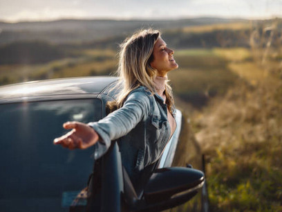 A woman gazing out of a car window, reflecting on a peaceful journey while embracing justice, trust, love, and compassion as essential elements of healing trauma
