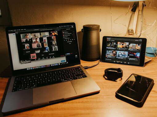 With a laptop placed on a brown wooden table, digital communication fuels online communities, enabling virtual interaction and social connection