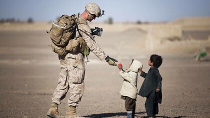 Soldier giving candy to children