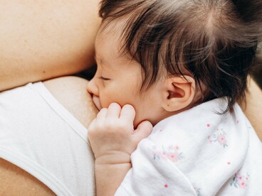 Mãe e bebê permanecem próximos durante a amamentação, em um momento de cuidado e contato. O leite materno reúne nutrientes e componentes bioativos associados às necessidades do bebê em diferentes fases do desenvolvimento