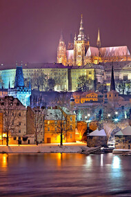 The Prague Castle District beautifully illuminates at night, casting a magical glow over the city