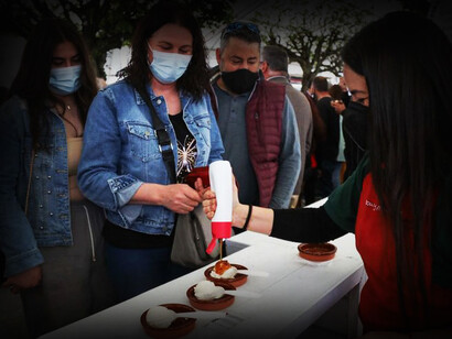 Camarera sirve a los comensales un plato con requeixo, un producto típico de la zona sur de Galicia, España