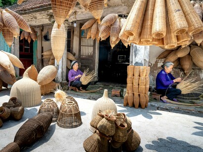 Skilled craftspeople in Vietnam creating woven baskets by hand, reflecting the preservation of cultural heritage through responsible travel