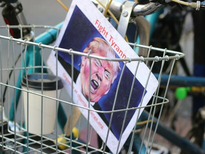 A paper with Donald Trump's image inside a bicycle basket, taken during the Los Angeles Women’s March