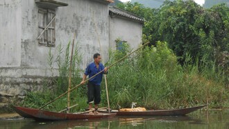 Vietnam. Vecino de Thung Nham remando en su pequeña embarcación