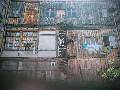 an inner yard of a rundown building, with a spiral ladder in the middle