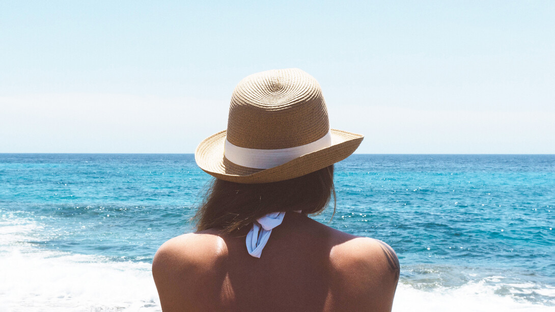 Donna in spiaggia davanti al mare. È tempo di raccogliere i frutti della nostra trasformazione ed esserne grati