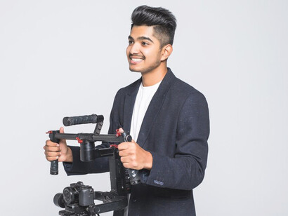 A young filmmaker beams with hope, illustrating the next generation of creators eager to bring fresh perspectives to an industry in need of revitalisation