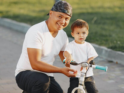 Pai ensina filho a andar de bicicleta