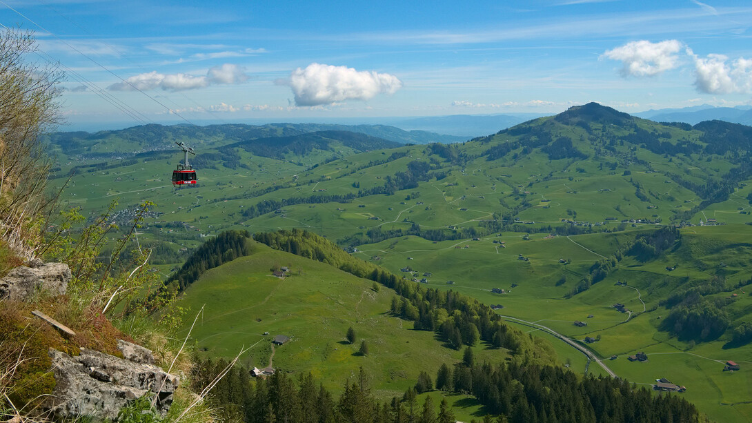 A car of the Luftseilbahn Wasserauen-Ebenalp in front of the landscape around Appenzell, Switzerland