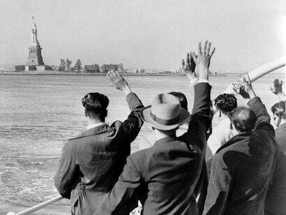 Inmigrantes saludando a la Estatua de la Libertad