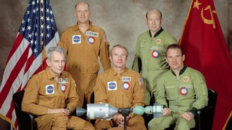 I cinque uomini che componevano i due equipaggi della prima missione spaziale cooperativa tra due nazioni avvenuta a luglio 1975, nota negli Stati Uniti come Apollo-Soyuz Test Project (ASTP) e in Unione Sovietica come Soyuz-Apollo Experimental Flight. Per l'equipaggio americano: Thomas P. Stafford (in piedi a sinistra), comandante; Donald K. Slayton (seduto a sinistra), pilota del modulo di aggancio; Vance D. Brand (seduto al centro), pilota del modulo di comando. Per l'equipaggio sovietico: Aleksey A. Leonov (in piedi a destra), comandante; Valeriy N. Kubasov (seduto a destra), ingegnere