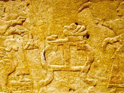 Bajorrelieve (aprox. 1.000 a.C.) del sarcófago de Ahiram de Biblos: el rey fallecido, en su trono (izquierda) recibe ofrendas dispuestas en una mesa