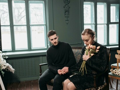 A sorrowful mother and her son share a moment of mourning during a quiet funeral ceremony