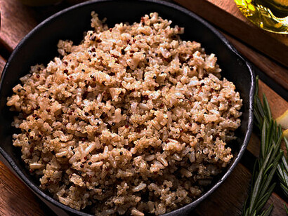 A nutritious quinoa bowl overflowing with vibrant ingredients, elegantly presented on a rich, dark wooden backdrop