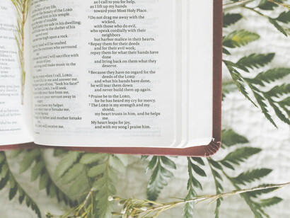 Salmos impresos en una biblia con helechos debajo y unas ramitas por arriba