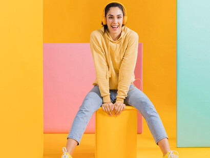 Happy woman enjoying music, smiling in front of a vibrant, colorful background