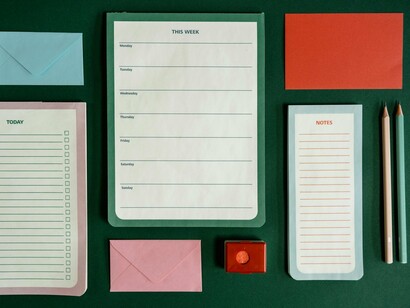 An empty schedule surrounded by notes and lists, reflecting the practice of creating structure from uncertainty