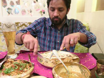 Hindu man dining at an Indian restaurant, savoring authentic Lucknowi biryani