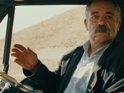 Il sapore della ciliegia, film di Abbas Kiarostami. Il lento spostamento della vettura permette di scorgere e di sentire varie persone, di diversa età e impiego nella società, una sorta di studio preliminare sull’universo circostante, fatto di umanità e vita