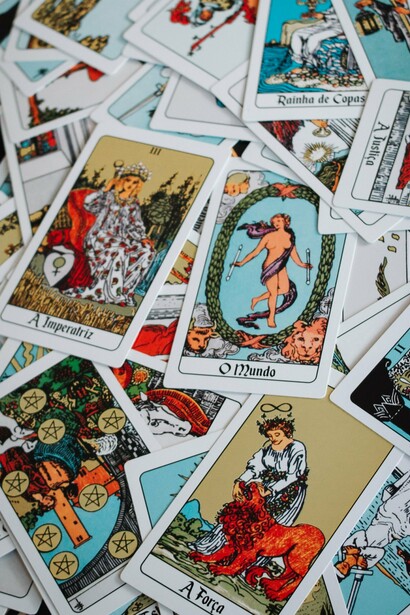 Um conjunto de cartas de tarot coloridas organizado para uma leitura. Mais do que prever acontecimentos, o artigo convida a refletir sobre o equilíbrio entre autoconhecimento e autonomia diante das interpretações