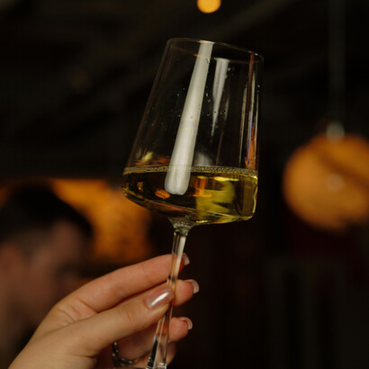 An elegant wine tasting scene in a cozy indoor setting, bathed in warm light
