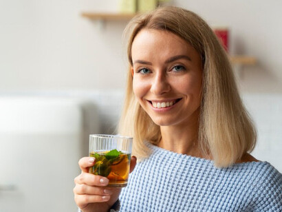 A woman sipping kombucha in a relaxed moment